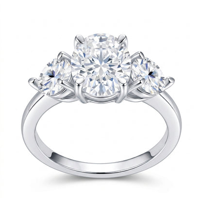 2.5ct oval cut moissanite three-stone ring with pear side stones on white background.