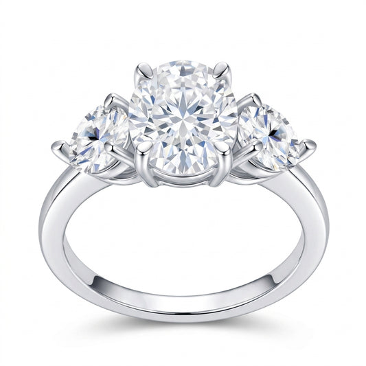 2.5ct oval cut moissanite three-stone ring with pear side stones on white background.