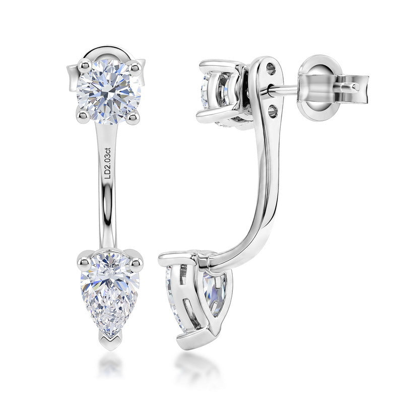 A pair of silver-toned drop earrings with a round brilliant-cut clear gemstone at the top and a pear-cut clear gemstone at the bottom, shown on a white background.