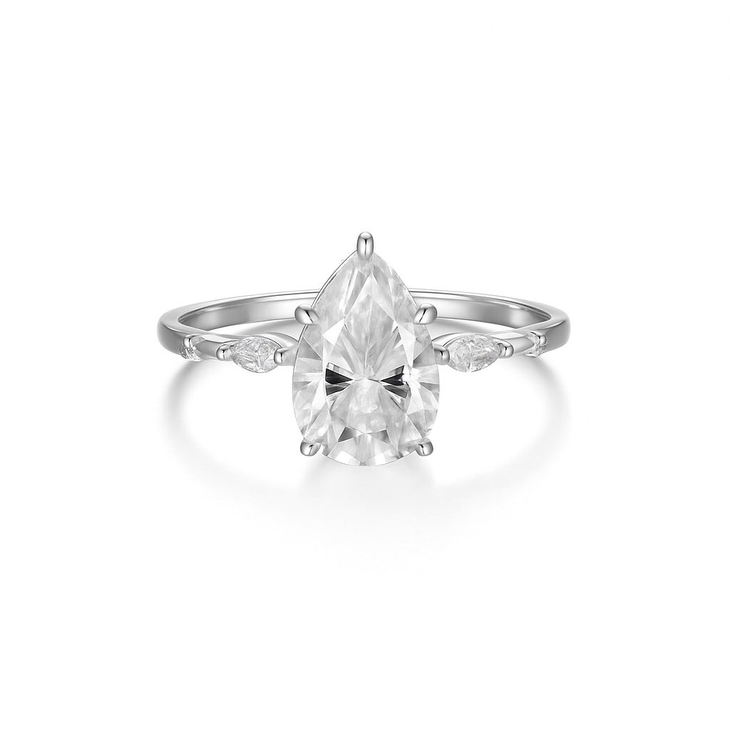  Yellow gold petal teardrop ring on soft romantic background. Alt: “2CT Petal-Shaped Teardrop Moissanite Ring – 18K Yellow Gold.”