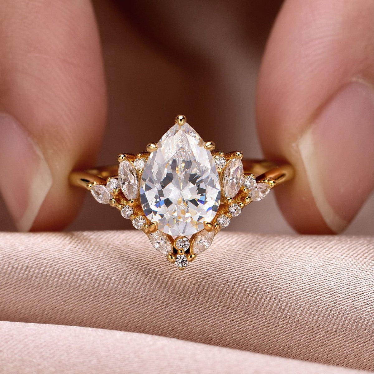 Yellow gold 2CT pear moissanite ring on soft romantic background. Alt: “2CT Water Drop Moissanite Engagement Ring – 18K Yellow Gold.”