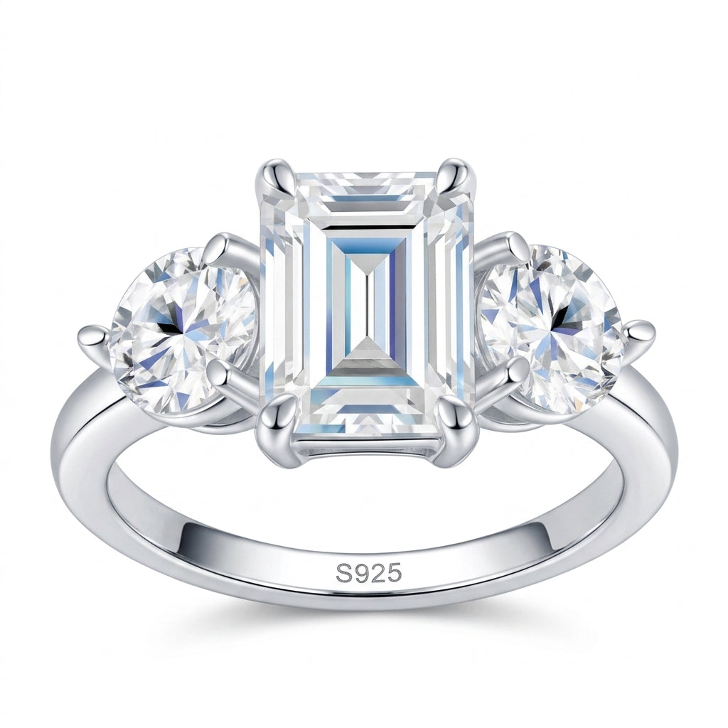 2ct emerald cut moissanite three-stone ring with round side accents on white background.