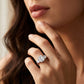 Close-up view of a model wearing 2ct emerald cut moissanite three-stone engagement ring.