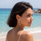 Model wearing 2CT lab grown diamond round pear Toi et Moi front back drop earrings by the sea.