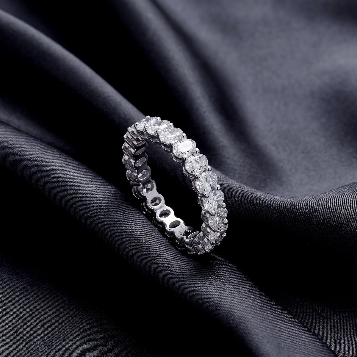 Angled view of 3.15 ctw oval cut lab grown diamond eternity ring resting on dark black silk