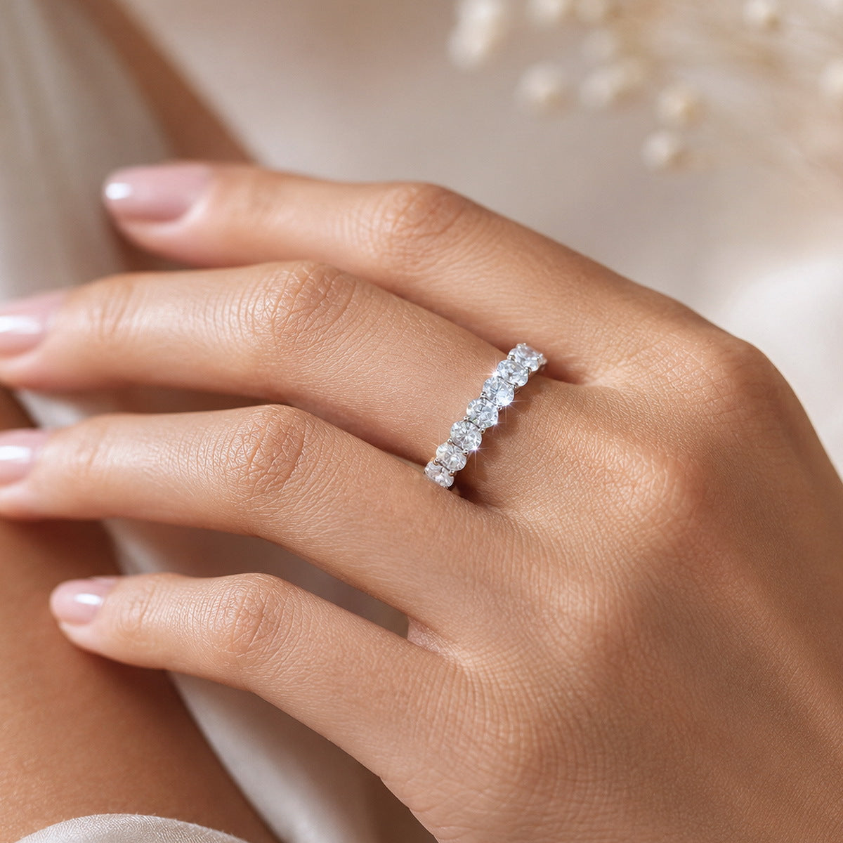 Close up view of woman wearing 3.15 ctw oval cut lab grown diamond eternity ring on hand