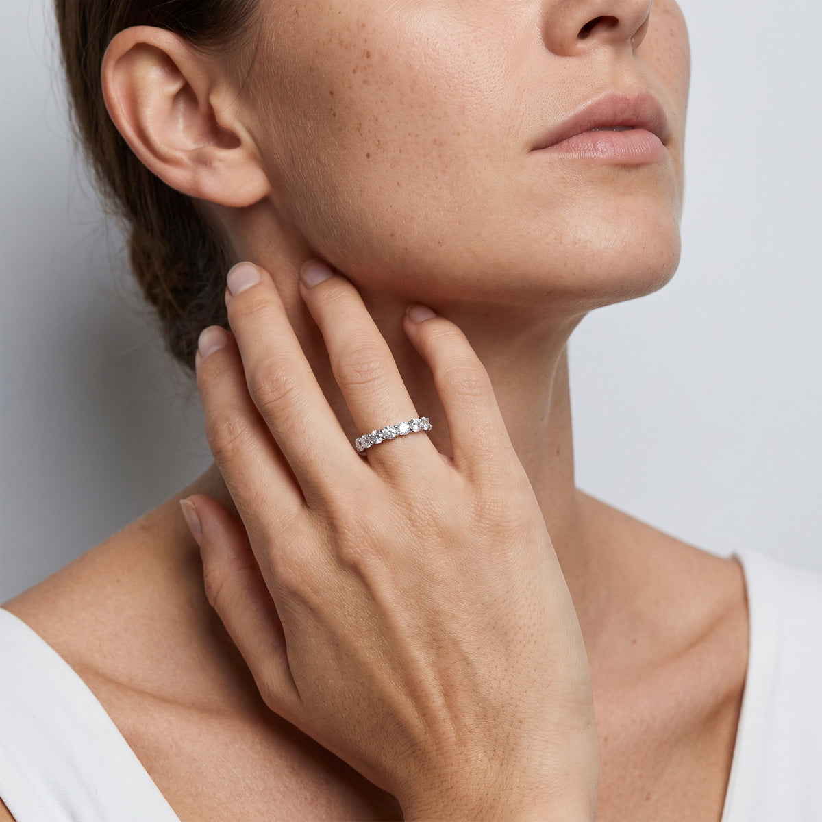 Woman wearing 3.84 ctw round cut lab grown diamond eternity ring on finger