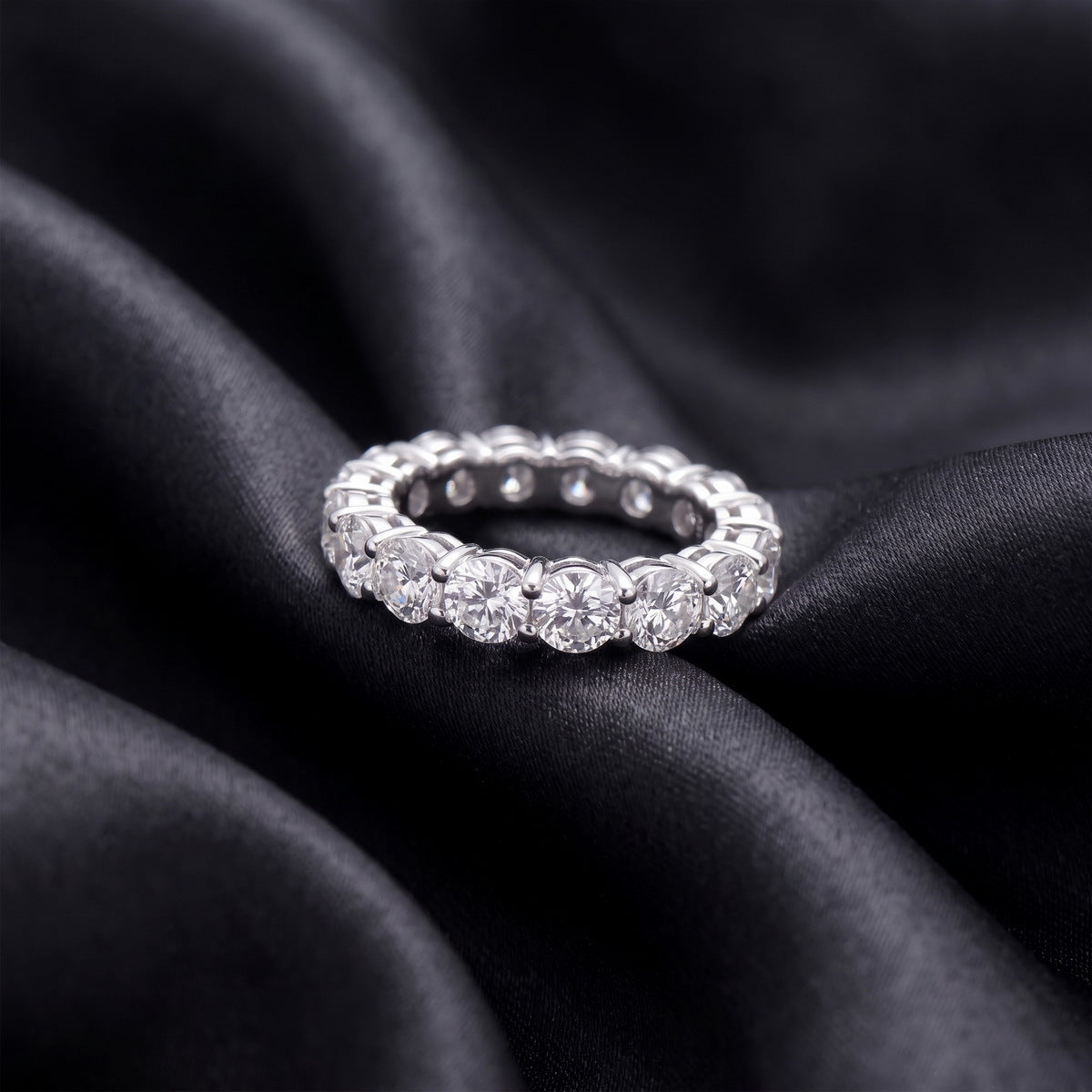 3.84 ctw round brilliant lab grown diamond eternity wedding band resting flat on dark black silk