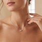 Model wearing 3-stone marquise cut lab grown diamond horizontal pendant necklace on collarbone.