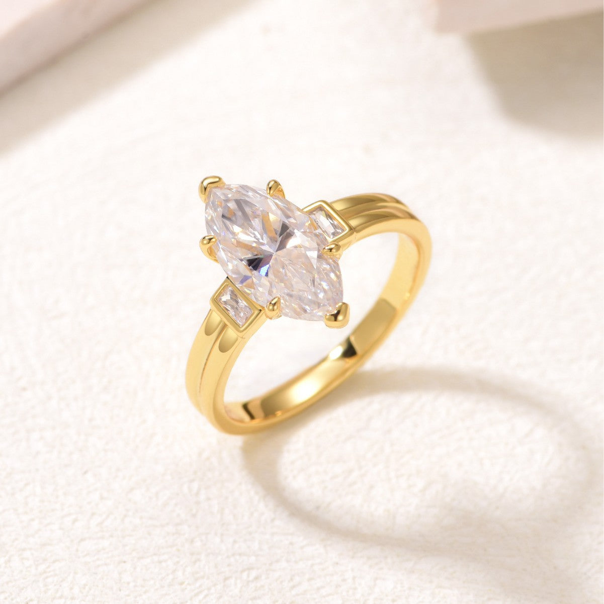 Yellow gold 3CT marquise moissanite ring on soft romantic background. Alt: “3CT Marquise Moissanite Engagement Ring – 18K Yellow Gold.”