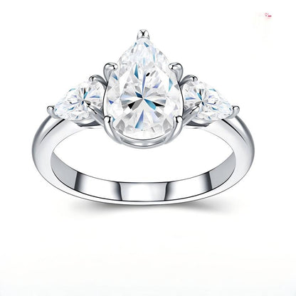 3CT pear cut moissanite three-stone engagement ring with pear side accents on white background.