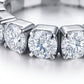 Macro view showing shared prong setting and round moissanite stones on eternity band.