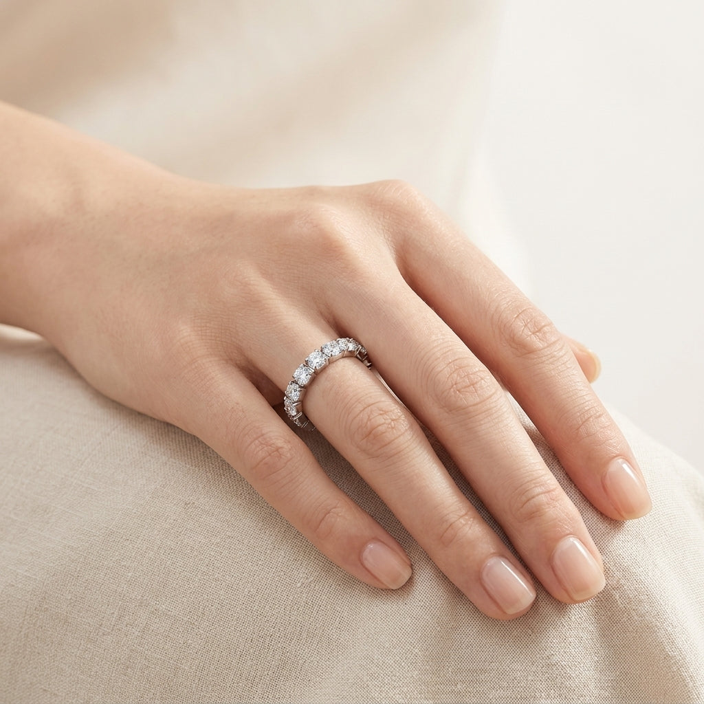 Close-up view of model wearing 3mm round moissanite eternity ring on hand.