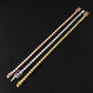 Three tennis-style bracelets with round stones in rose gold, silver, and yellow gold, arranged diagonally on a black textured background.