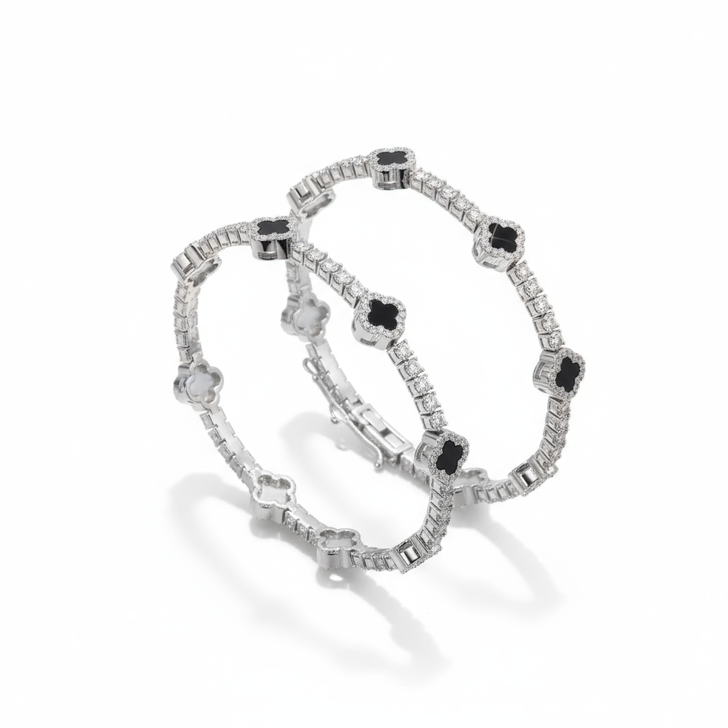 Pair of silver bracelets with black gemstones on a white background