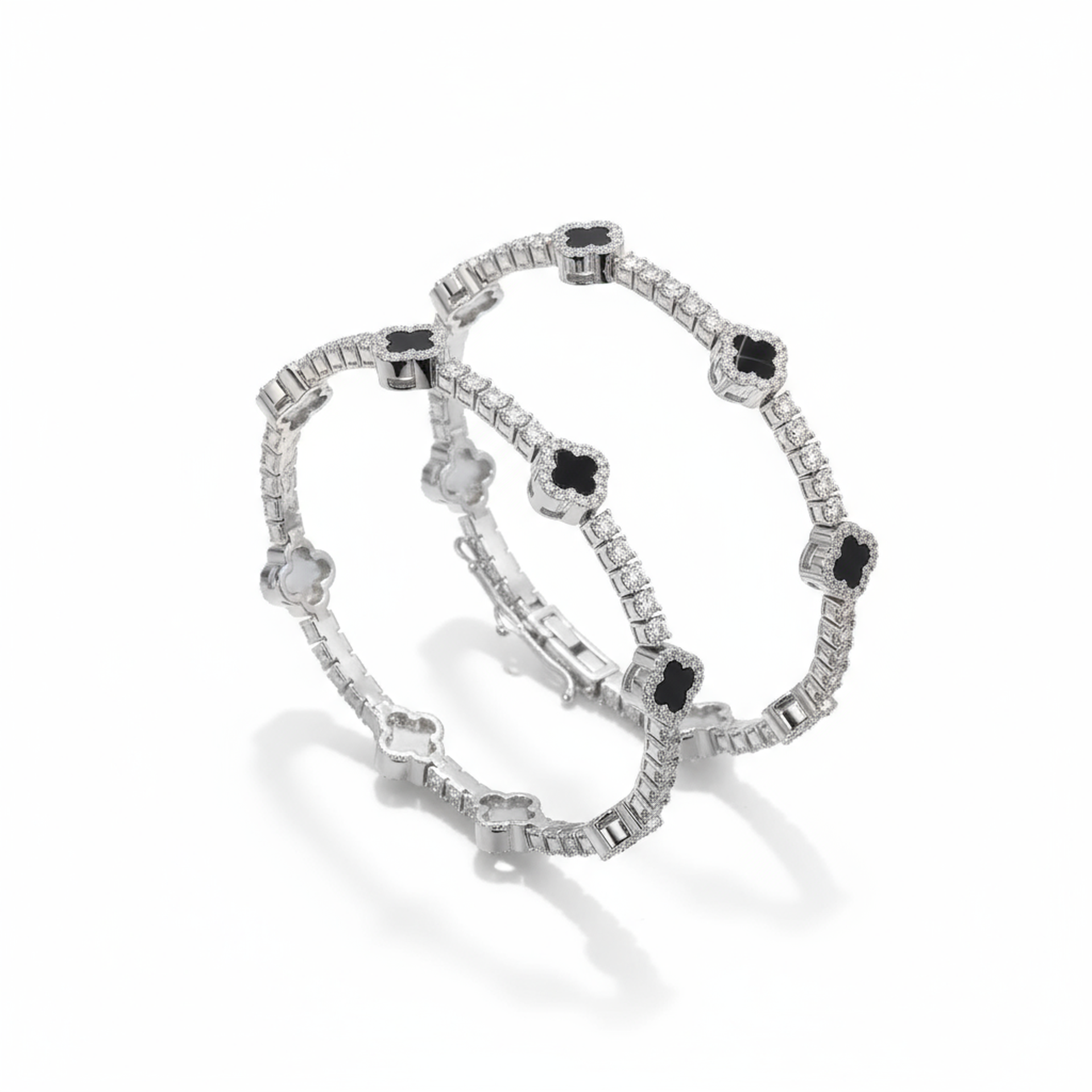 Pair of silver bracelets with black gemstones on a white background