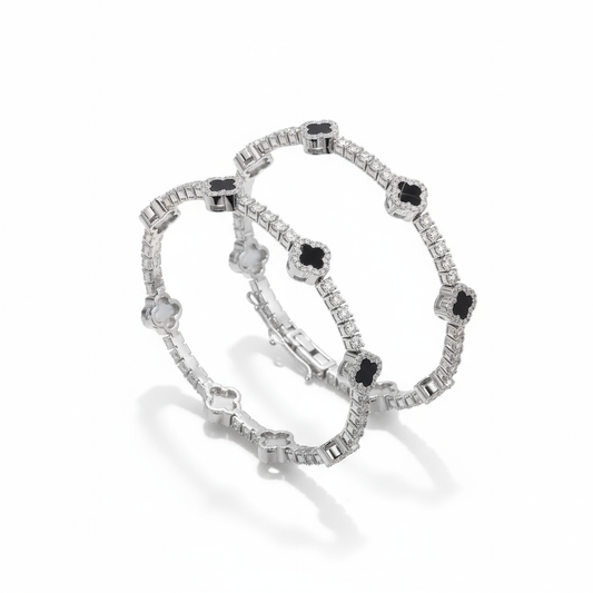 Pair of silver bracelets with black gemstones on a white background