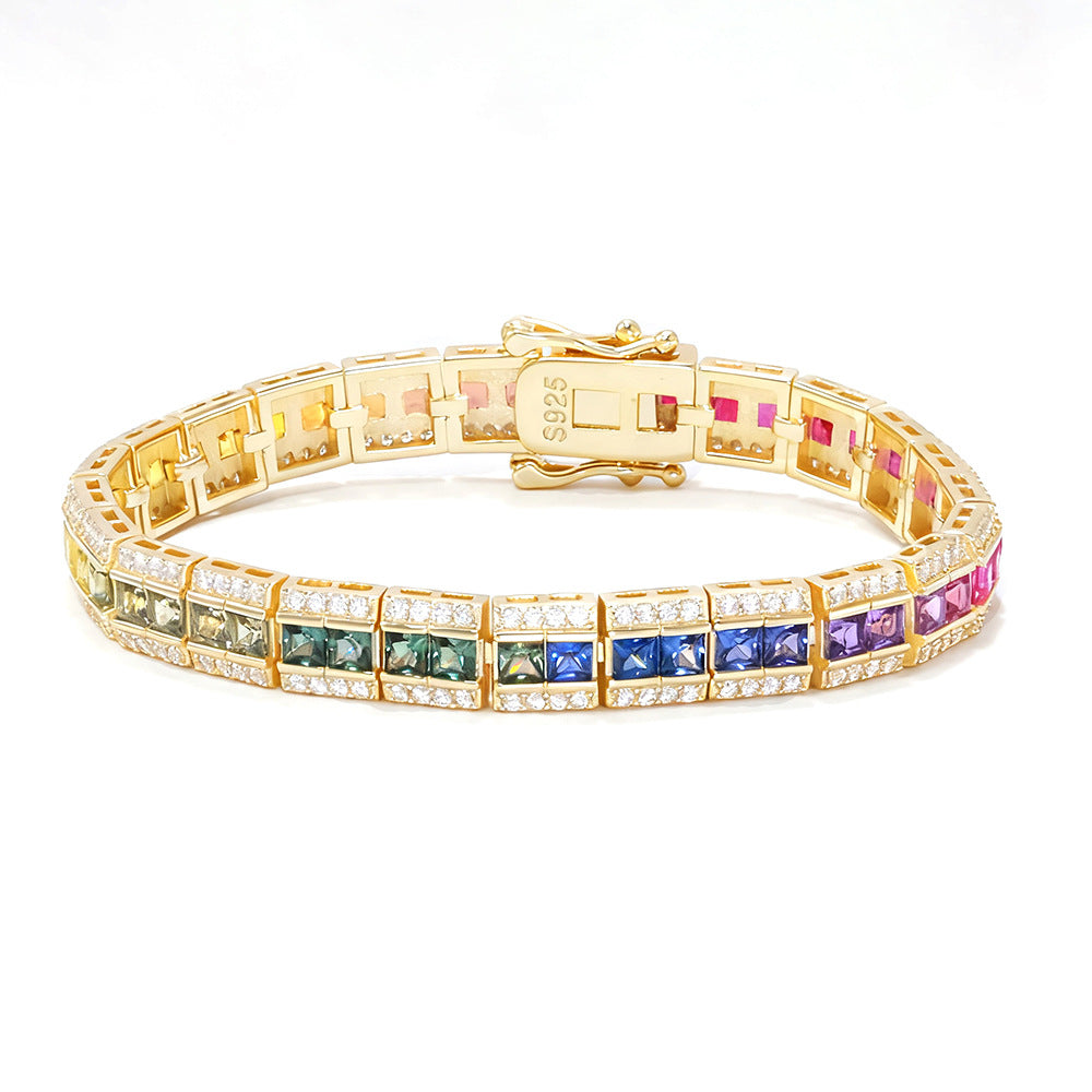 Gold 3x3mm princess cut rainbow channel-set tennis bracelet with pave borders and box clasp on white background