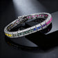 Silver 3x3mm princess cut rainbow channel-set tennis bracelet displayed on dark stone background