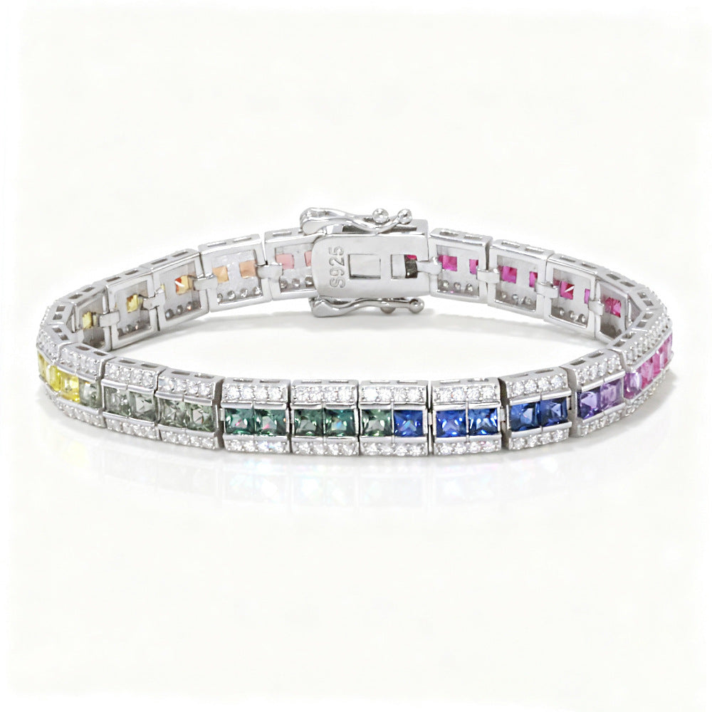 Silver 3x3mm princess cut rainbow channel-set tennis bracelet with pave borders on white background