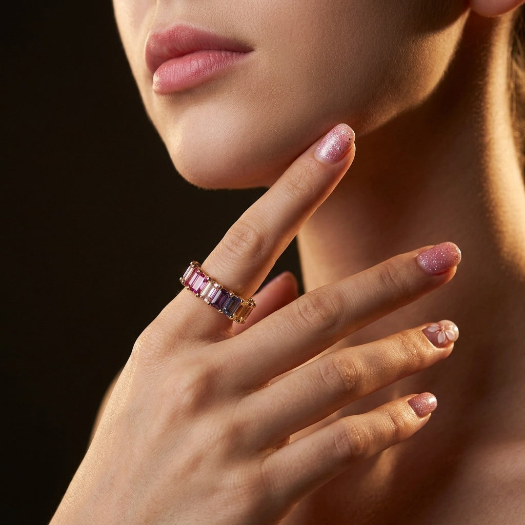 Model wearing gold 3x5mm emerald cut rainbow gemstone eternity band ring on hand