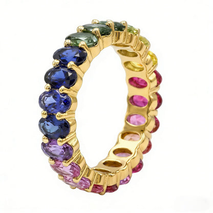 Gold 3x5mm oval cut rainbow eternity band ring with multi-color gemstones isolated on white studio background