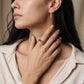 Model wearing gold 3x5mm oval cut rainbow gemstone eternity band ring on hand
