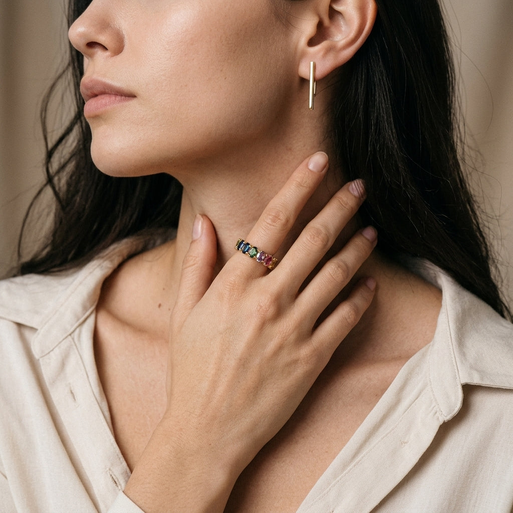 Model wearing gold 3x5mm oval cut rainbow gemstone eternity band ring on hand