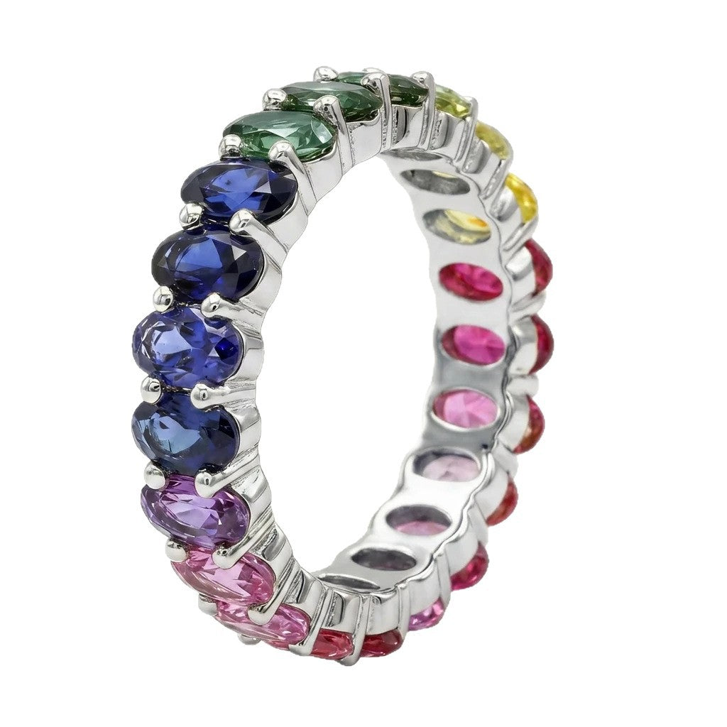 Silver 3x5mm oval cut rainbow eternity band ring with multi-color gemstones isolated on white background