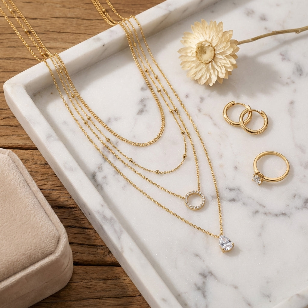 Top-down, necklaces on marble tray, styled with earrings, ring, dried flower, velvet box, warm soft tones, balanced composition, clean e-commerce aesthetic, high resolution.