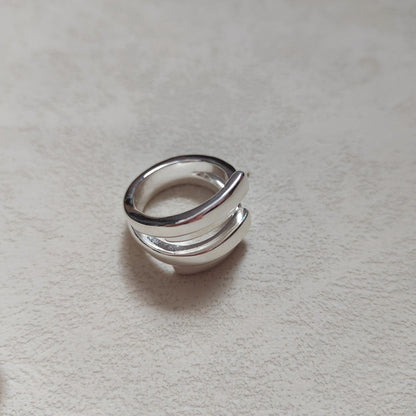  Irregular open ring on neutral background. Alt: “UNOde50 Irregular Open Ring – Textured Silver Asymmetric.”