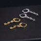 Pair of silver iced out pear cut and 3-stone drop dangle huggie hoop moissanite earrings on GRA certificate card
