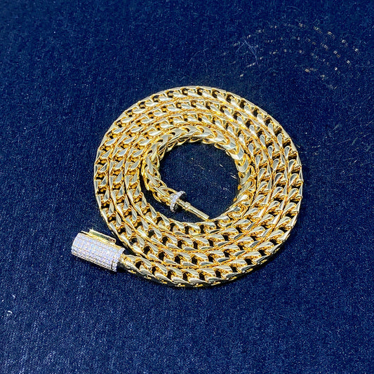 4mm franco chain necklace in 14k yellow gold plated 925 sterling silver with iced out moissanite box clasp coiled on dark surface