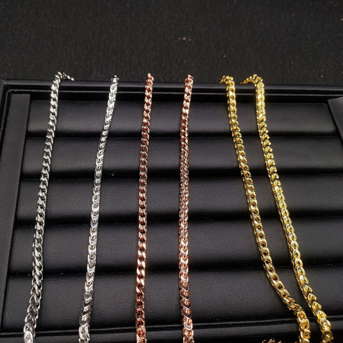 Yellow gold 4mm franco chain necklace coiled on gloved hand with iced out moissanite clasp