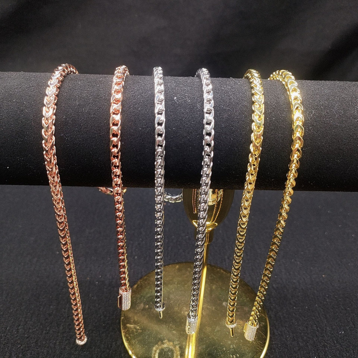 Silver 4mm franco chain necklace links and iced out moissanite box clasp on carbon fiber background