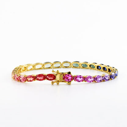 Gold 4x6mm oval cut rainbow gradient moissanite tennis bracelet with double safety box clasp on white background   