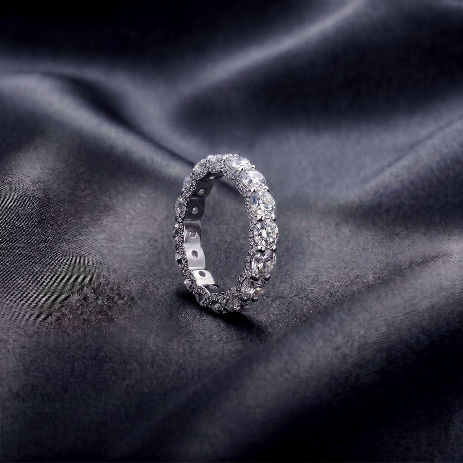 5.17ctw round cut diamond simulant eternity ring standing upright on dark silk.