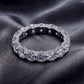 Top-down view of 5.17ctw eternity ring highlighting side pave basket detail on dark silk.