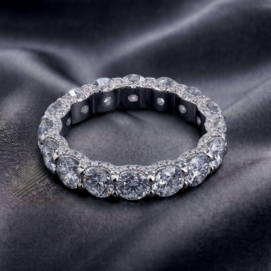 Top-down view of 5.17ctw eternity ring highlighting side pave basket detail on dark silk.