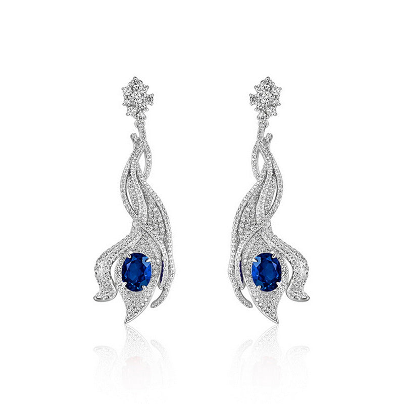 Luxury 5ct oval-cut royal blue sapphire wave earrings, sterling silver halo setting.