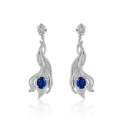 Luxury 5ct oval-cut royal blue sapphire wave earrings, sterling silver halo setting.