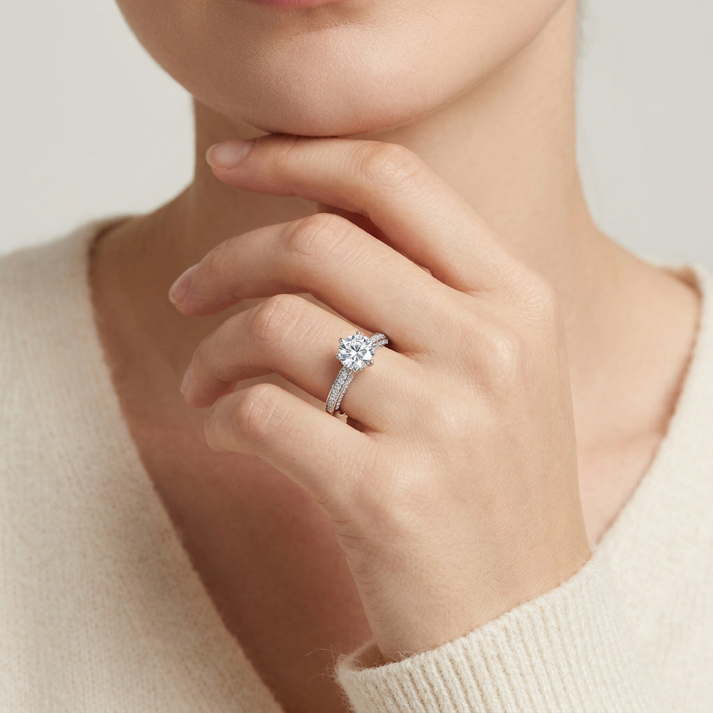 Model wearing the classic 6-prong round moissanite engagement ring with micro-pavé band.