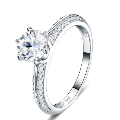 Classic 6-prong round cut moissanite solitaire engagement ring with pavé side stones in 925 sterling silver.