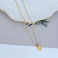 Necklace on a soft, bright background (light blue or creamy white), highlighting the sun pendant's pearl center and crystal halo. Alt: “Kate Spade Sunny Pave & Imitation Pearl Halo Necklace – Radiant Sun Motif Jewelry.”