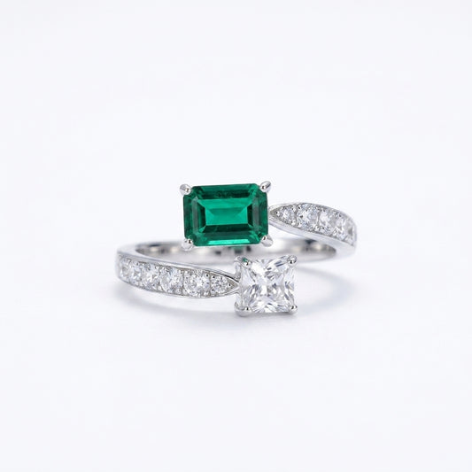 White background front view of a 925 sterling silver two-gemstone ring featuring a step-cut lab emerald and a square diamond.