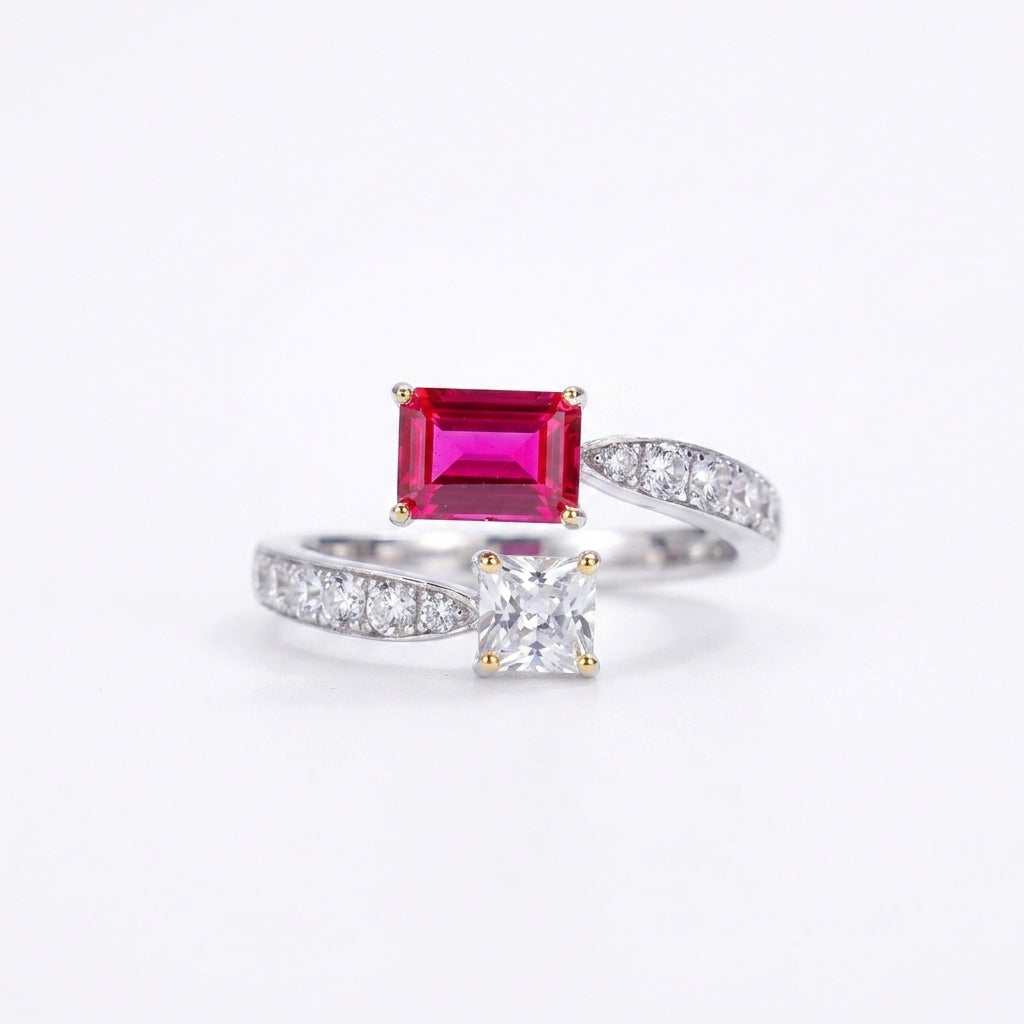 White background front shot of a 925 sterling silver two-stone engagement ring featuring an emerald-cut lab ruby and a princess-cut gem.