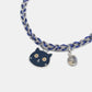 Bracelet with a cat charm and blue and silver braided design on a white background