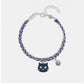 Bracelet with a cat charm and blue beads on a white background