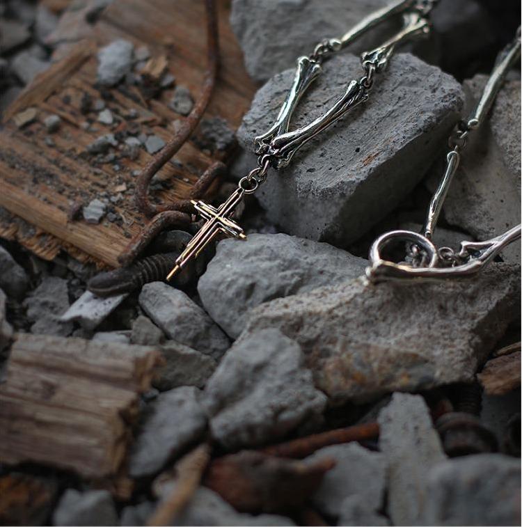“Texture detail of handcrafted bone engraving on silver cross pendant”