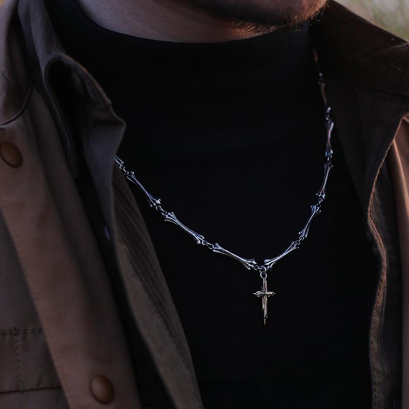 “Male model wearing gothic silver bone cross pendant necklace”
